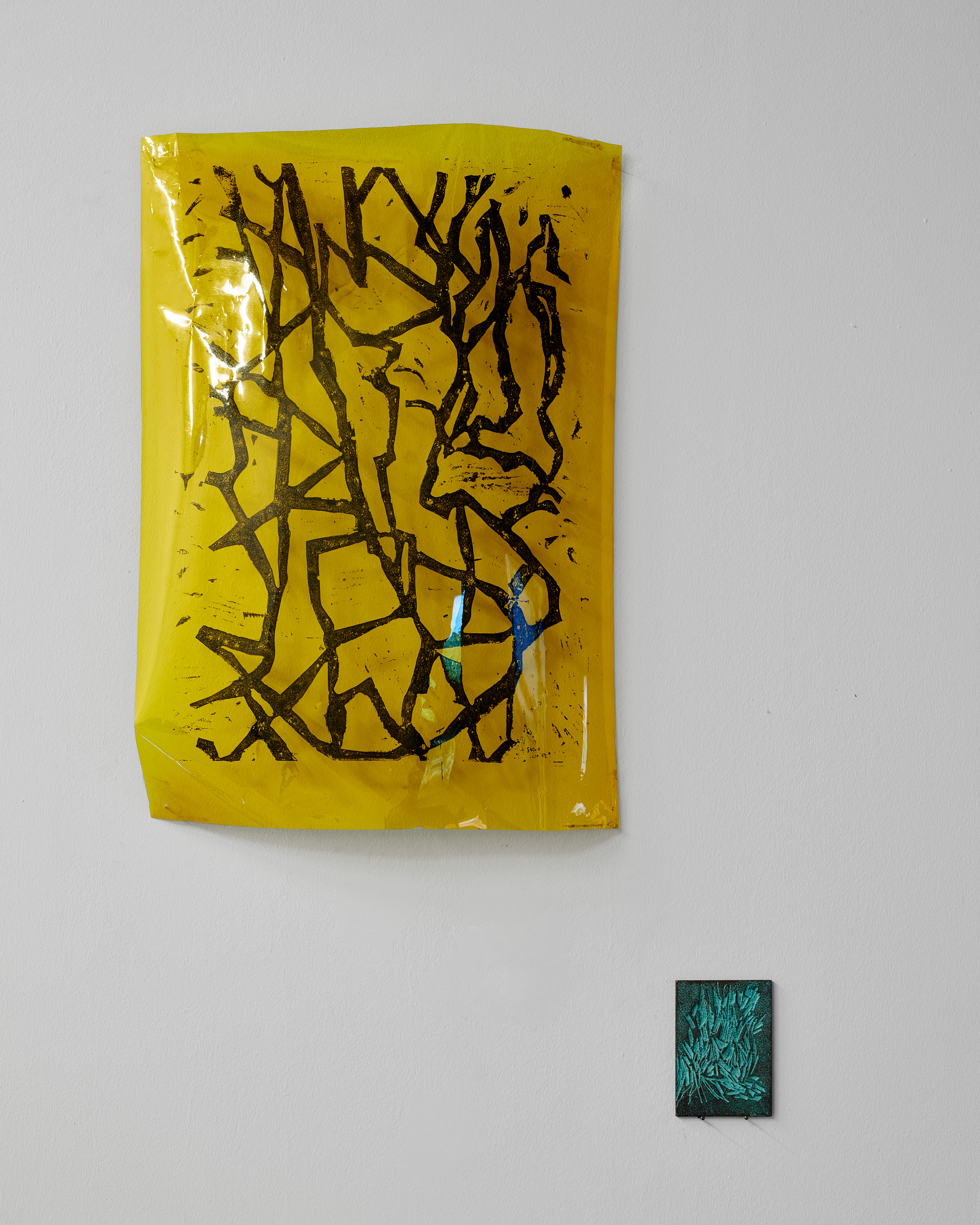 Nahansicht zweier Arbeiten von Till Bick: ein Druck auf Folie und ein kleines Bronzerelief